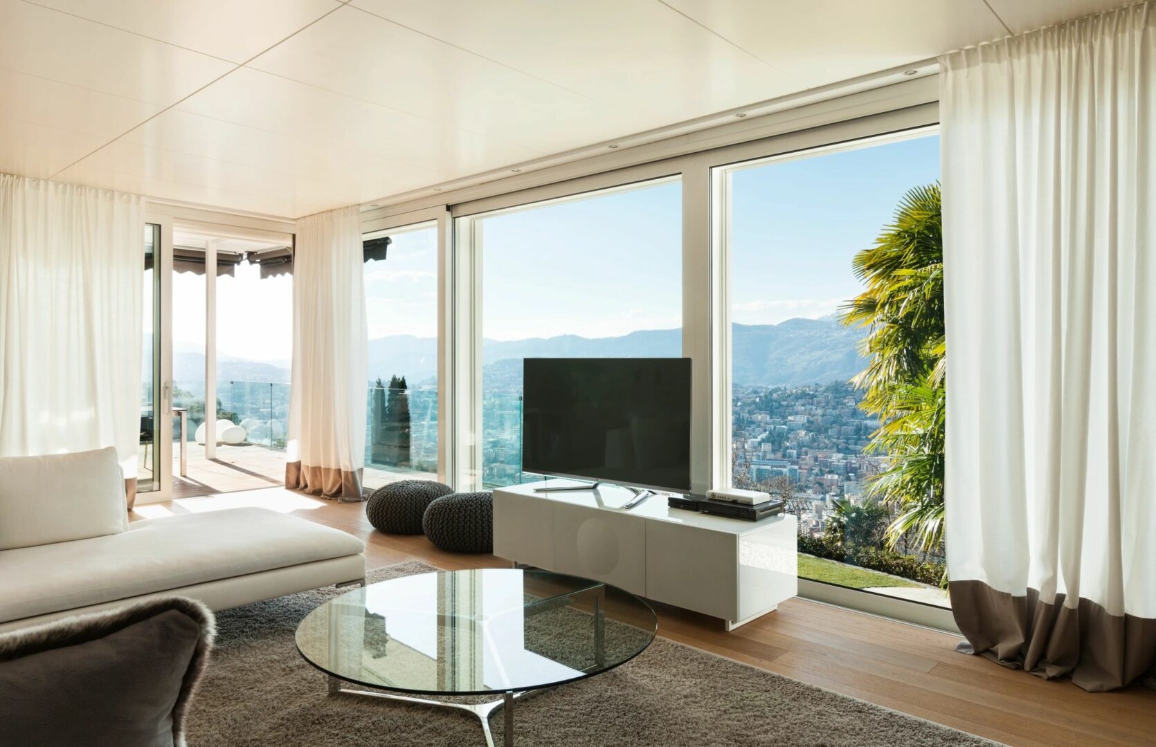 A living room with large windows and a view of the mountains.