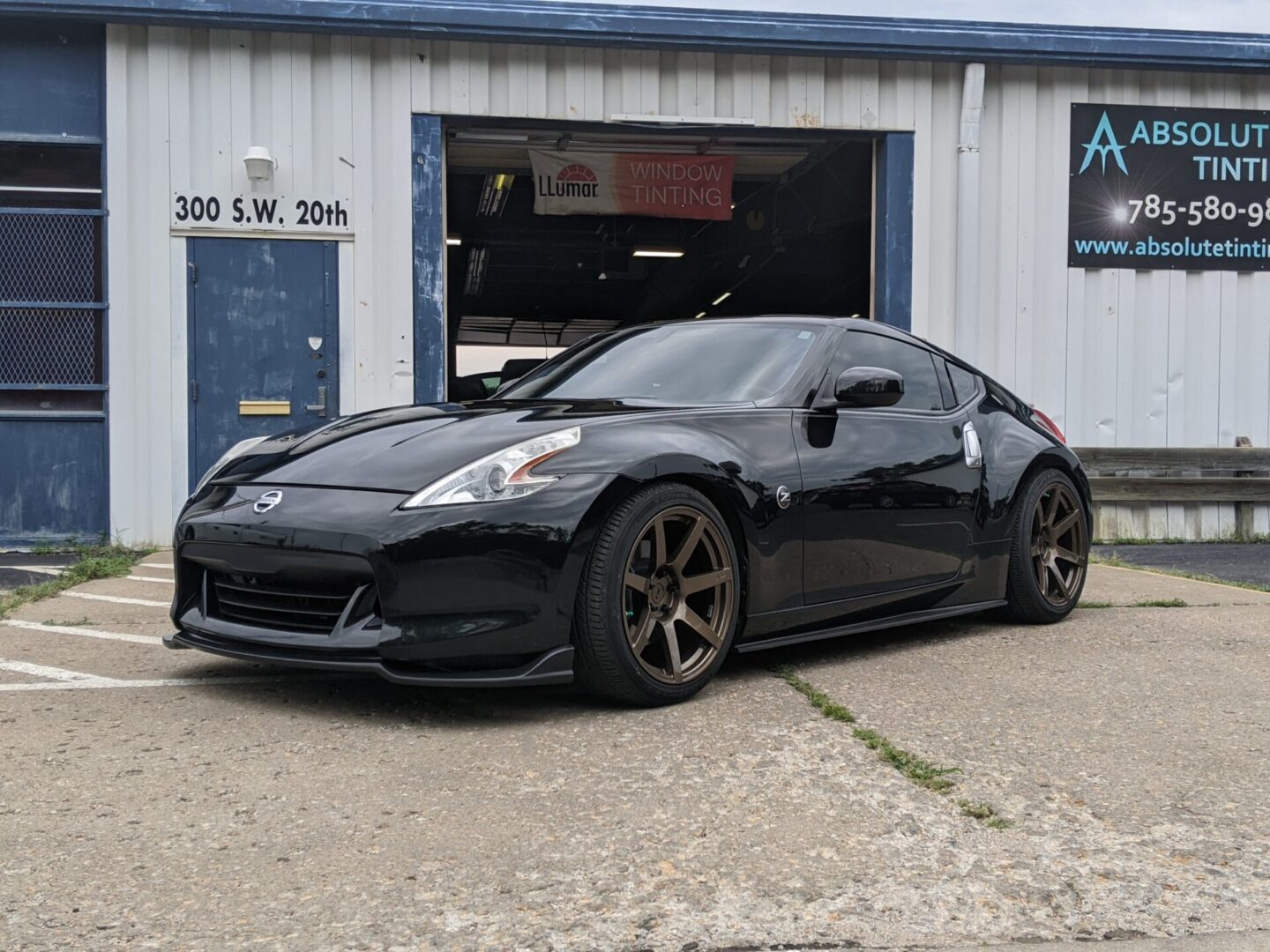 A black car parked in front of a garage.